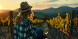 Fototapeta Przestrzenne - Woman enjoying sunset in a vineyard with a glass of wine