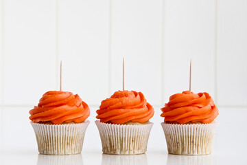 Wall Mural - Three Orange Cupcakes Topper Mockup. Styled against a white background . 3 cupcake Copy space for your design here. Halloween, fall design