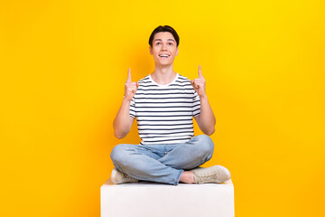 Poster - Photo of excited funky guy dressed striped t-shirt looking showing two fingers up empty space isolated yellow color background