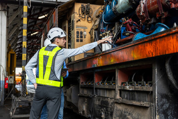 Wall Mural - Team railway engineer Inspect repair project train diesel engine in maintenance center. Technician discuss planning checking vehicle and railroad systems.