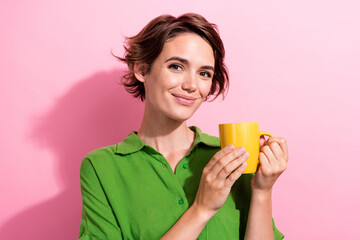 Sticker - Photo portrait of lovely young lady hold coffee mug dressed stylish green garment isolated on pink color background