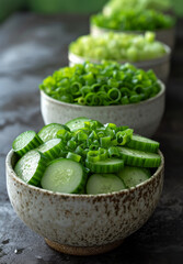 Fresh sliced cucumbers and green onions in ceramic bowl