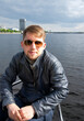 Portrait of young man in fashion sunglasses on board a yacht in the Baltic Sea, Riga. Latvia. Concept of a short holiday on the water. Relaxed Man.