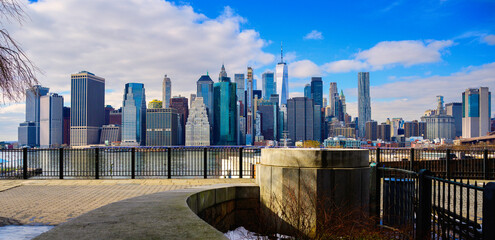 New York City Lower Manhattan Skyline and skyscrapers over the curving footpath at Brooklyn Heights Promenade in New York, USA, with snow melting