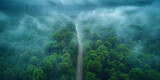Fototapeta Zwierzęta - An aerial view captures a dramatic storm with lightning over a lush forest, with a road cutting through the misty landscape..