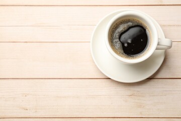 Canvas Print - Cup of aromatic coffee on light wooden table, top view. Space for text