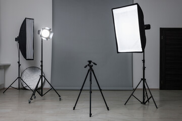 Canvas Print - Modern light grey photo background and professional lighting equipment in studio