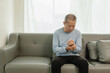 © ArLawKa - An elderly Asian male patient suffers from pain and numbness in his hand from rheumatoid arthritis. Elderly man massaging hand with pain in wrist health problems concept