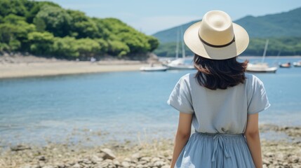 Young woman traveler in a hat on a summer holiday standing near her car by the sea