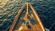 The prow of a big wooden yacht cutting through the sea, symbolizing the allure of luxury sailing.