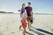 © Marko Geber - Happy family walking on sunny beach