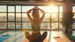 Woman Practicing Yoga During Sunrise. Silhouette of a woman in a peaceful yoga pose with hands in namaste, overlooking a sunrise cityscape from a studio. Mental Health Day concept.