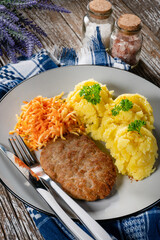 Wall Mural - Minced meat cutlet served with mashed potatoes and carrot salad.