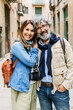 © Xavier Lorenzo - Portrait of senior attractive couple smiling at camera at city street. Vertical photo