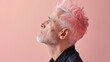 Profile of senior men with pink hair on pastel background.