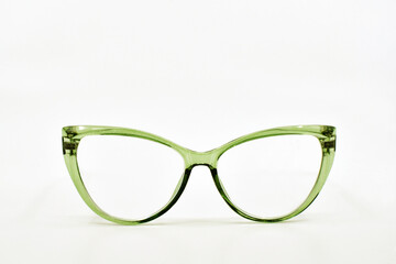 Wall Mural - Pair of cat eye shape glasses with green frames isolated on a plain white background. Copy space. Eyesight concept.