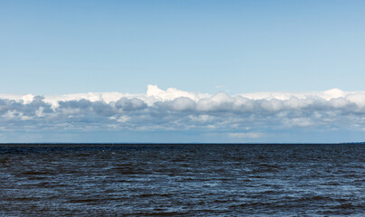Wall Mural - Baltic Sea water is under blue sky with white clouds on a sunny day