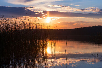 Wall Mural - dramatic landscape with colorful sunset sky over calm still lake