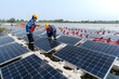 © ultramansk - Male workers repair Floating solar panels on water lake. Engineers construct on site Floating solar panels at sun light. clean energy for future living. Industrial Renewable energy of green power.