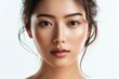 Attractive Asian lady with flawless skin and a stylish ponytail looking innocent with natural makeup and expressive eyes posing on a white backgrou