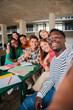© Jose Calsina - Happy young students taking a vertical selfie portrait together at university library. African american guy shooting a photo with his smiley classmates on a high school meeting. Friends at academy