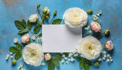 Wall Mural - Composition with blank card and delicate flowers on blue background 