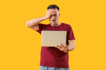 Wall Mural - Stressed young man with laptop on yellow background. Deadline concept