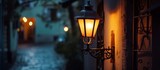 Fototapeta Uliczki - Evening Glow: a solitary street light casting shadows in a narrow alleyway