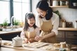 © shelbys - A mother and daughter cooking together in the kitchen