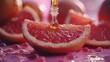 Dripping grapefruit essential oil from pipette into bottle and fresh fruit on table, closeup