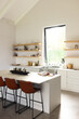 A modern kitchen features white cabinetry, a central island with bar stools, and open shelving with 