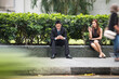 © Image Smith - Two Asian business people using there phones.