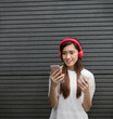 © Image Smith - Chinese woman using a Smart Phone and headphones.