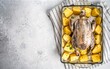 Cooking of Raw guinea fowl with potato in baking dish. White background