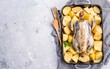 Cooking of Raw guinea fowl with potato in baking dish. White background