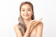 © Shutter B - A smiling young Asian woman presenting with an open hand against on white background., ideal for product placement. Skincare and health wellness, Facial treatment, Perfect skin, Natural makeup.