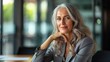 © Ruslan Gilmanshin - Smiling stylish mature middle aged woman sits at desk portrait. Happy older senior businesswoman, 60s grey-haired lady looking at camera sitting at office table