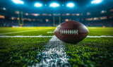 Fototapeta Sport - American football on a lush green field under stadium lights, capturing the anticipation and excitement of a night game in professional sports