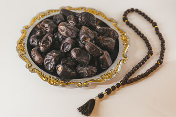 Wall Mural - Arabian tray with dates and wooden rosary. Islamic holidays concept.
