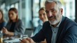 © MagicS - Portrait of a man in a meeting room discussing a project with colleagues