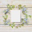 Framework for invitation or congratulation, round frame with flowers on a wooden background. 