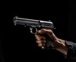 Close up of a man holding a gun in his hand against black background