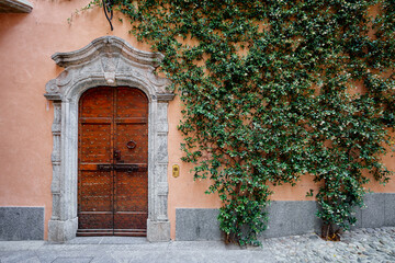 Sticker - Ancient stone wall of old building with wooden vintage door.