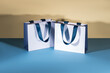 Blue and white paper shopping bags mockup with blue handles	
