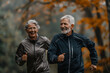 © barmaleeva - Senior couple jogging in the park. Running in park in the morning. Generative AI