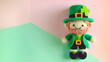 Crocheted leprechaun St. Patrick's on pastel background