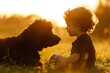 Kind mit lockigen Haaren und schwarzem Hund, atmosphärisch