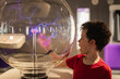 © ADDICTIVE STOCK - Curious boy exploring plasma globe at a science museum