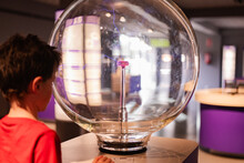 Curious Child Engaging With Science Exhibit At Museum
