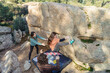 © ADDICTIVE STOCK - From above of focused climbers work in unison on a boulder problem outdoors, with a spotter ensuring their safety